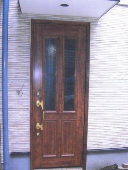 木の質感を再現した木目色のアンティーク調の建具玄関ドアに交換